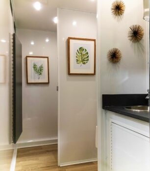 A bathroom with two paintings hanging on the wall.