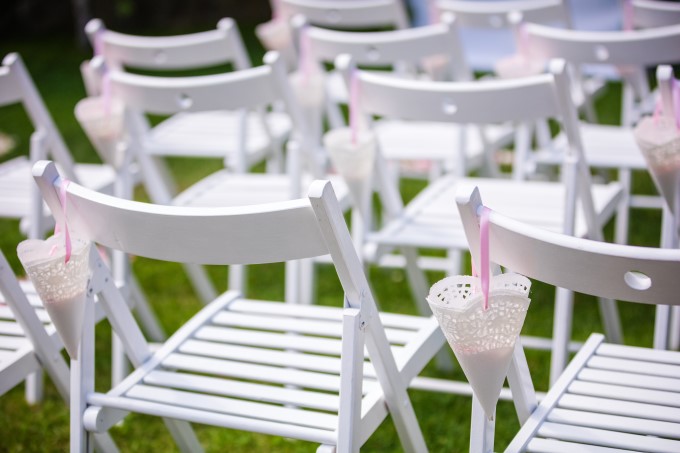 A white chair with pink straws and a drink in it.