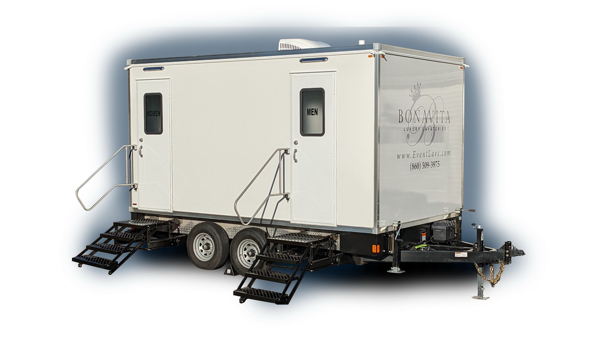 A white trailer with two toilets on it.