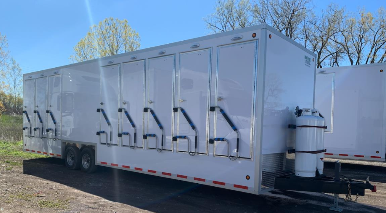 A white trailer with many doors and handles.