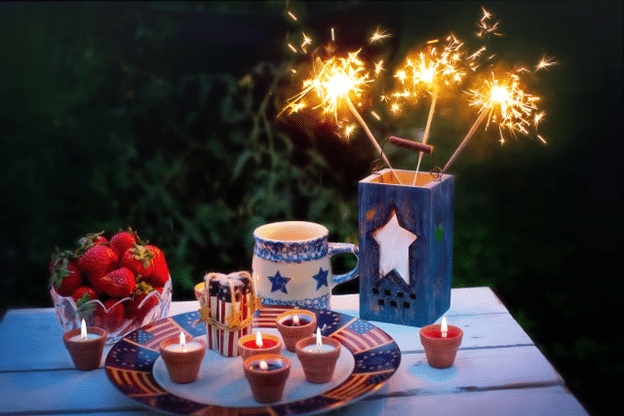 Fourth of July table setup with candles, strawberries, and sparklers