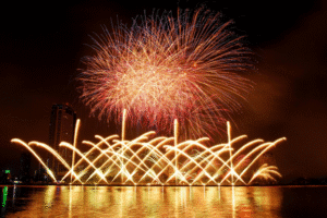 Fourth of July fireworks lighting up the night sky over a waterfront city