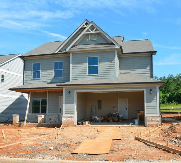 New house under construction with unfinished driveway and garage space