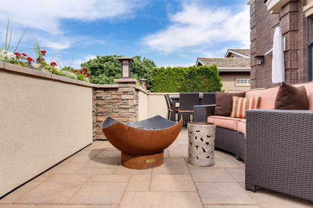 Stylish backyard patio with cushioned seating and a metal fire pit