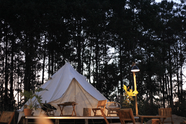 Canvas glamping tent on a deck at twilight.