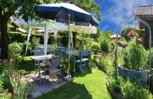 Backyard party setup with umbrellas and tables.