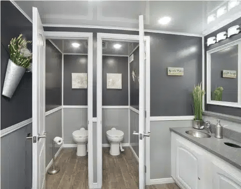 Interior of luxury restroom trailer with private stalls and vanity.
