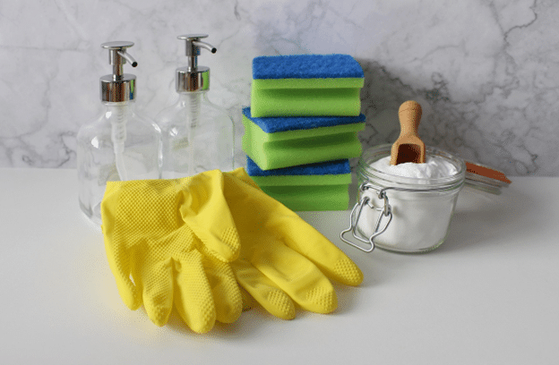 Eco-friendly restroom cleaning supplies—gloves, refillable soap dispensers, sponges, and deodorizing powder.