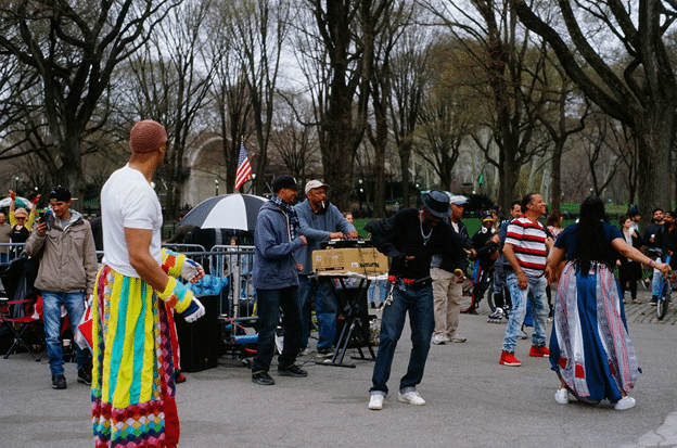 Crowd enjoying an outdoor parade and street performance.
